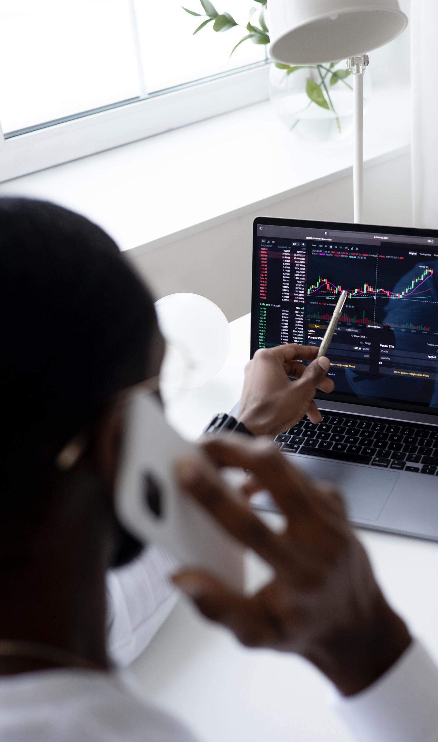man-on-the-phone-pointing-at-stock-chart
